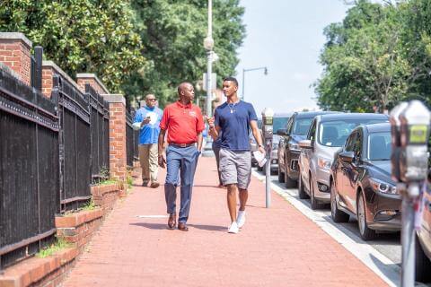 President Frederick walking and talking with student